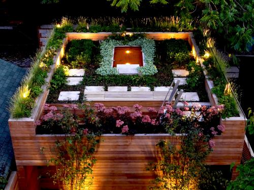 Illuminated roof garden with a pond at night